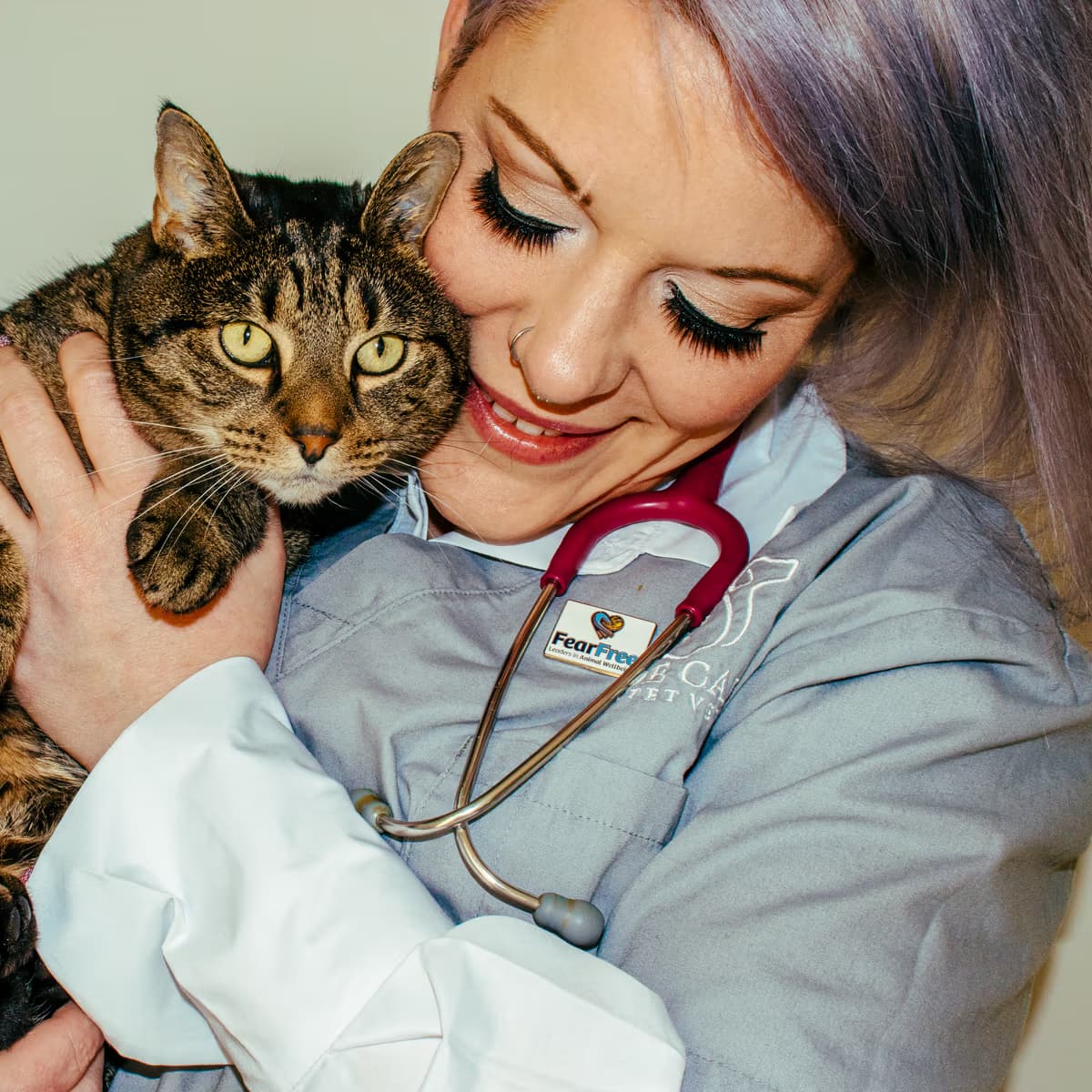 Dr Chantelle McGowan holding a relaxed tabby cat close during a Fear Free consultation